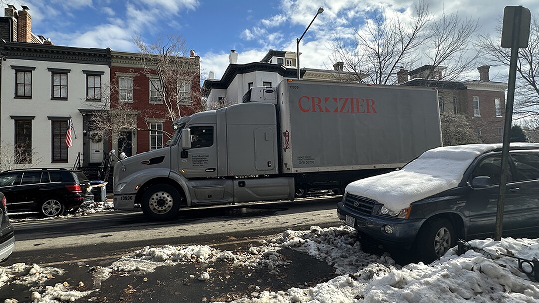 A large truck is parked on a snowy street.