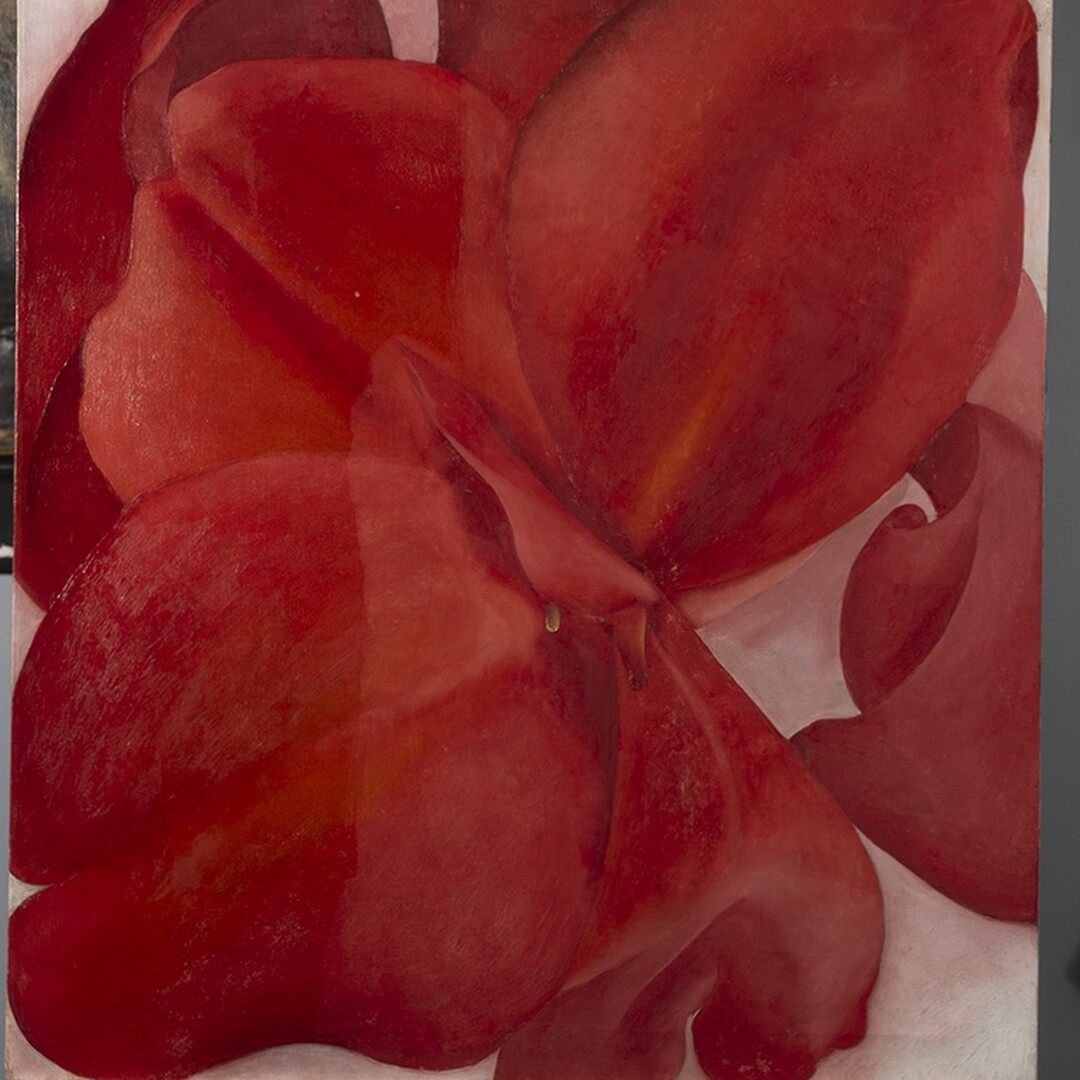 An oil painting on an easel of an extreme close-up, abstracted view of a red flower.