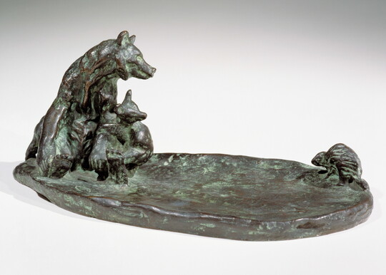 A bronze sculpture of a mother bear and her cub keeping a safe distance from a porcupine.