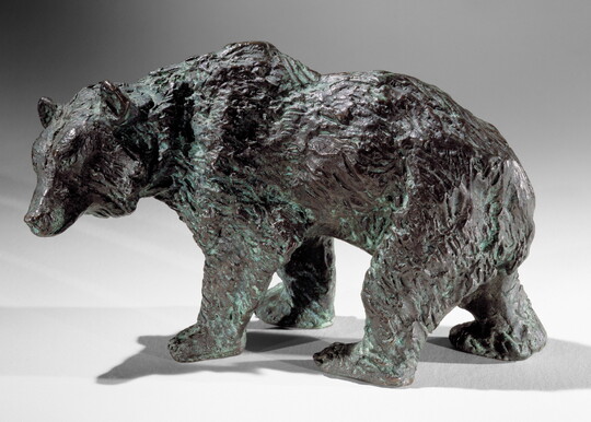 A bronze sculpture of a walking bear.