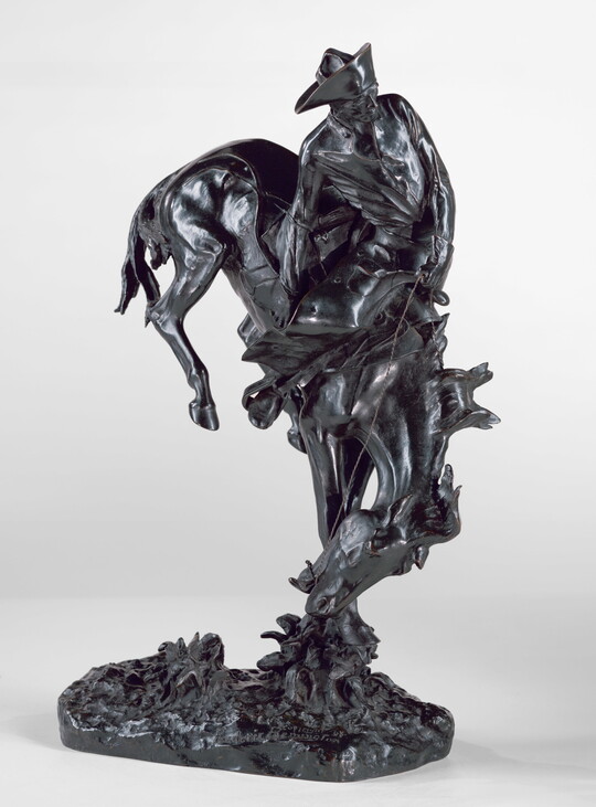 A bronze sculpture of a cowboy hanging onto a bucking bronco.