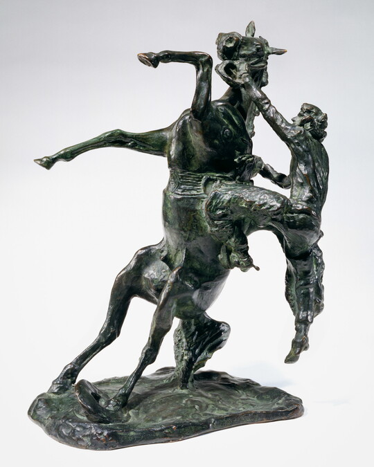 A bronze sculpture of a cowboy falling off the back of a rearing horse.