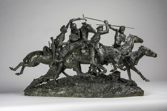A bronze sculpture of Native American and White figures on horseback fighting with swords and spears.