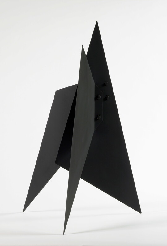 A black abstract tabletop sculpture with lots of triangular points.