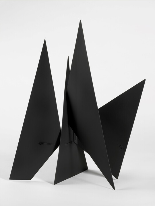 A black abstract tabletop sculpture with lots of triangular points.