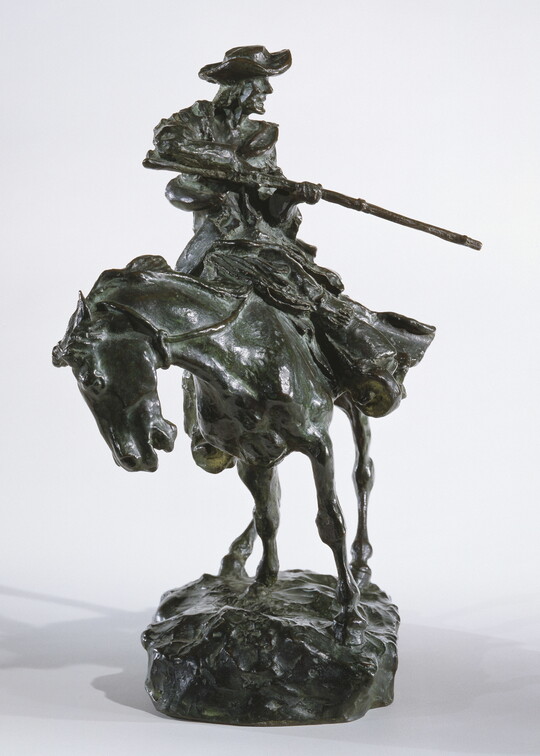 A bronze sculpture of a man on horseback pointing a long rifle.