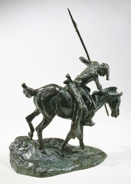 A bronze sculpture of an Indigenous man on horseback holding a spear pointed toward the ground as he studies footprints there.