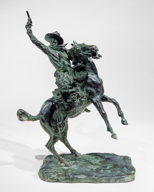 A bronze sculpture of a man pointing a gun up high over his head while on a rearing horse.
