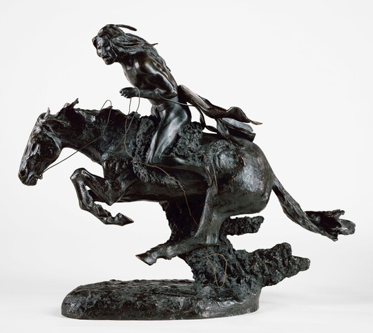 A bronze sculpture of an Indigenous man riding a running horse.