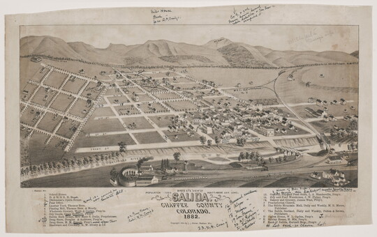 A black-and-white print of a bird's eye view of a town showing the grid of roads on a flat plain with mountains in the distance.