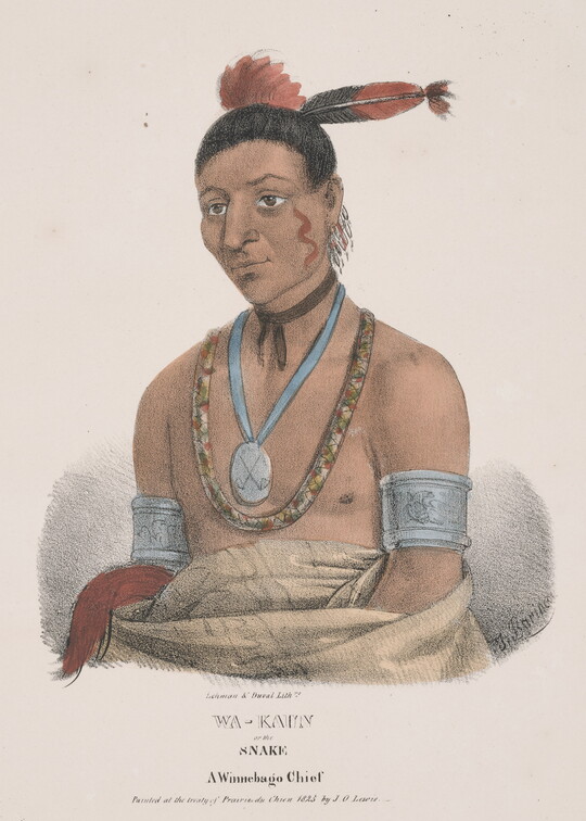 A color print of an Indigenous man, dark hair topped with red and black feathers, curvy red line on his face, a silver medallion and beaded necklace on his chest, silver arm bands, and a blanket around his torso.