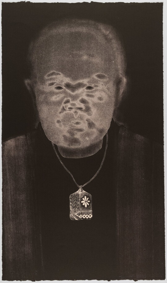 A black-and-white print of an abstracted man with Asian features, a gray face, and wearing a delicate patterned necklace all on a black background.