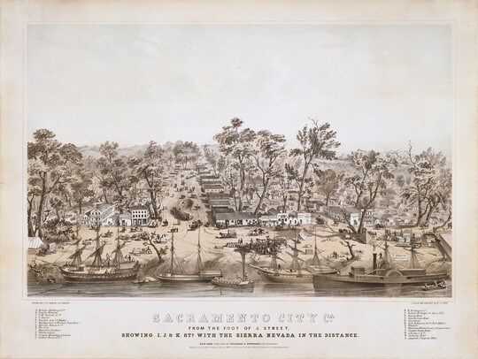 A sepia-toned print of the riverfront of a bustling town with rows of buildings and horse-and-wagon traffic.