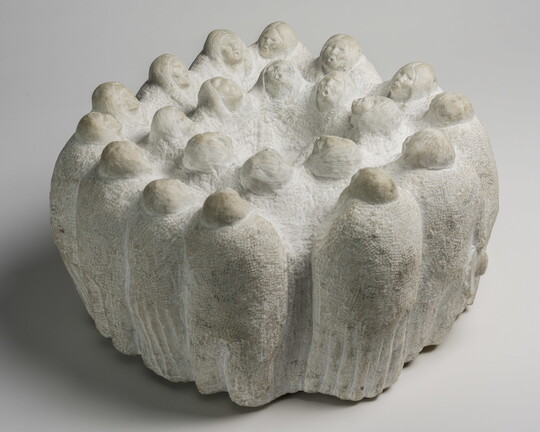 A marble sculpture of figures, all facing inward, in two concentric circles.