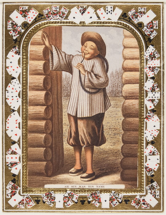 A color print of a man with Asian features wearing a hat and a long braid that loops around his arm leaning in the doorway of a log cabin; playing cards make up the decorative border.