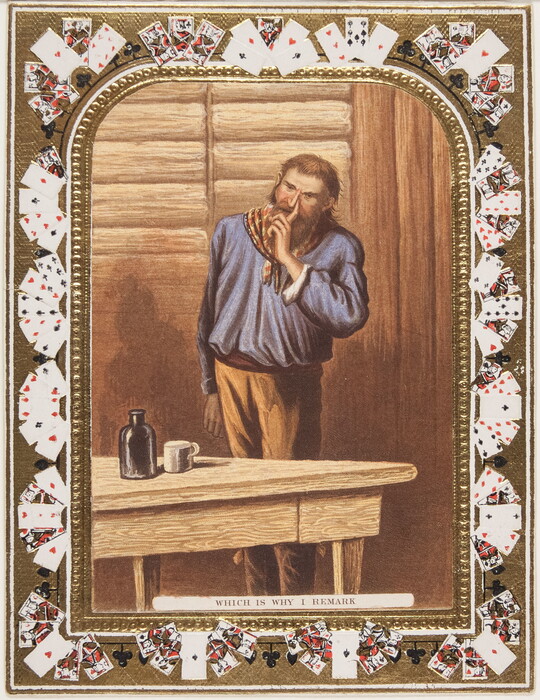 A color print of a White man with a long beard wearing a red and yellow bandanna, finger next to his nose, standing next to a wood table; playing cards make up the decorative border.