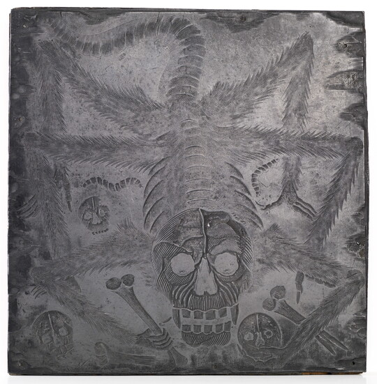 An engraved metal printing plate of a spider with a skull as a head, holding bones and skulls in its claws.
