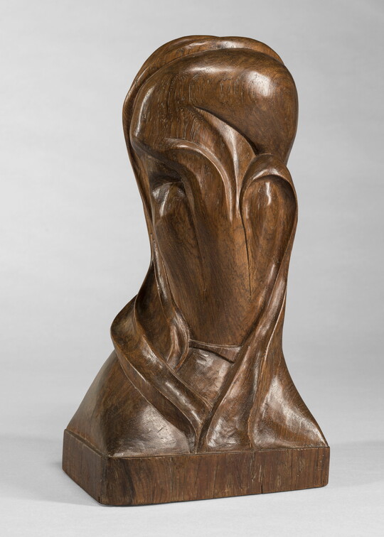 A mahogany sculpture representing an abstracted head.