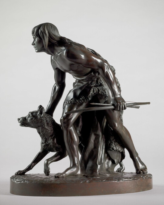 A bronze sculpture of a young Indigenous man holding a bow and arrow, standing hunched low with a dog beside him.