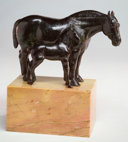 A bronze sculpture of two horses, a mare and a foal, standing next to each other on a stone base.