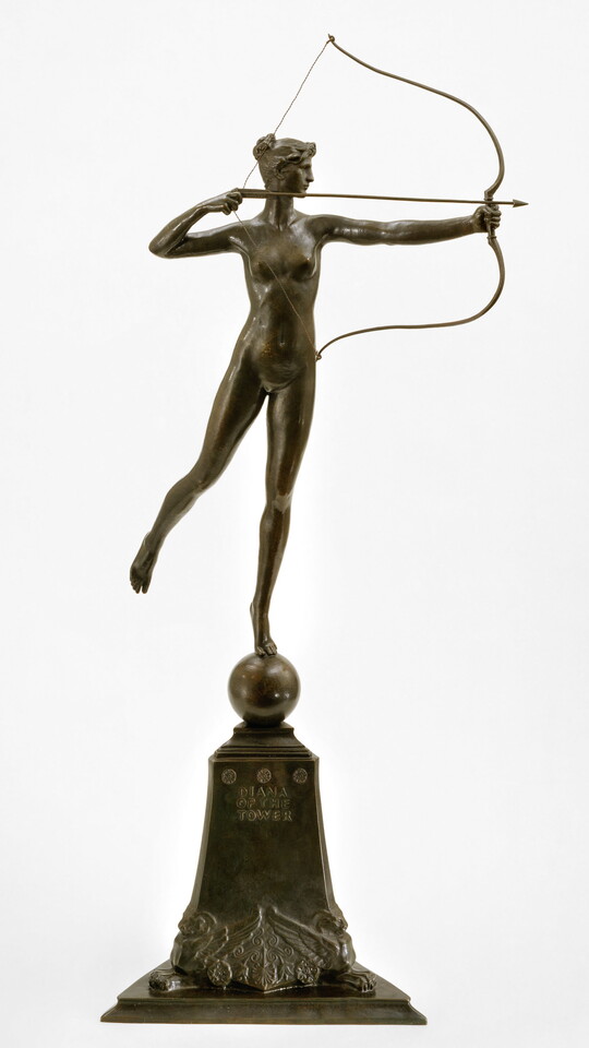 A bronze sculpture of a nude goddess shooting a bow and arrow from on top of a pedestal.