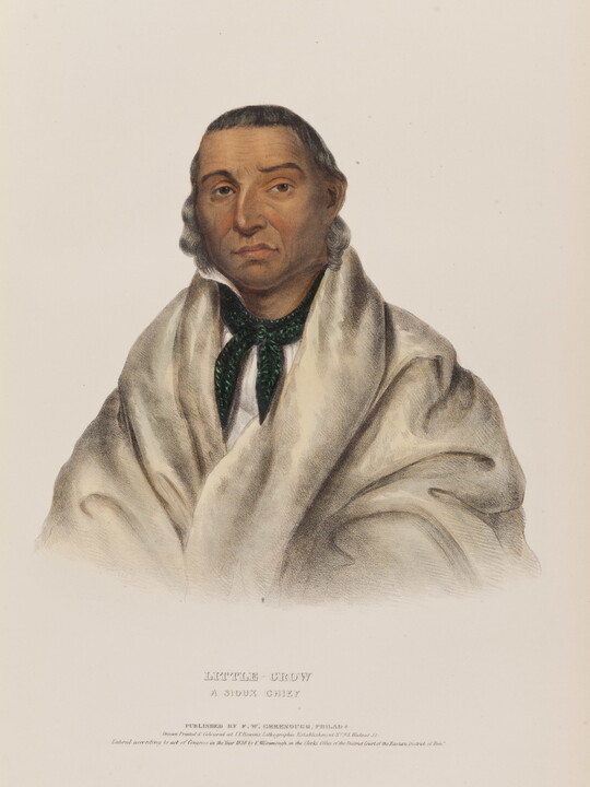 A color print portrait of an Indigenous man wrapped in a white blanket with a bandanna round his neck.
