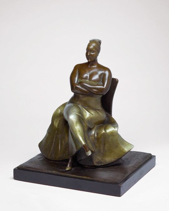 A bronze sculpture of a woman wearing an evening gown sitting with her legs and arms crossed.