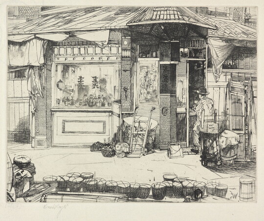 A black-and-white print of a person seated at work in front of a building with Asian details; a line of baskets on the street in the foreground.
