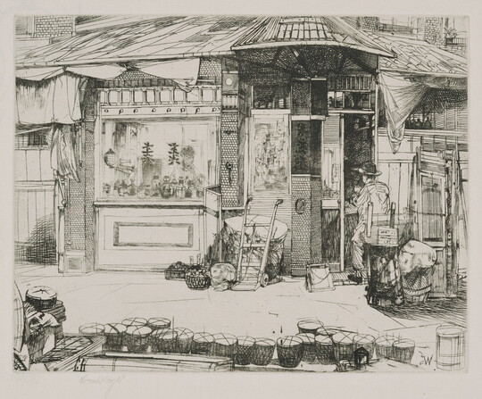 A black-and-white print of a person seated at work in front of a building with Asian details; a line of baskets on the street in the foreground.