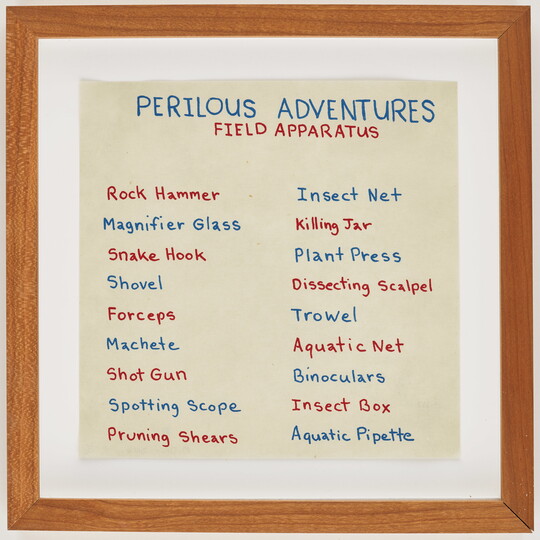 A small square framed print of a supply list of adventure gear in blue and red handwriting.