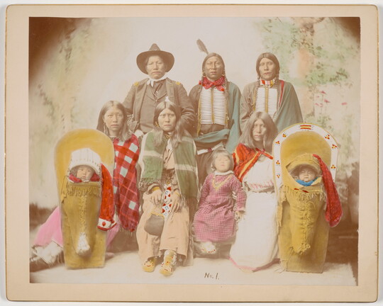 A color photograph of an Indigenous family, including two babies in cradleboards.