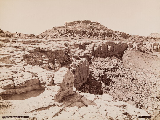 A black-and-white photograph of a rocky landscape and a dry gully.