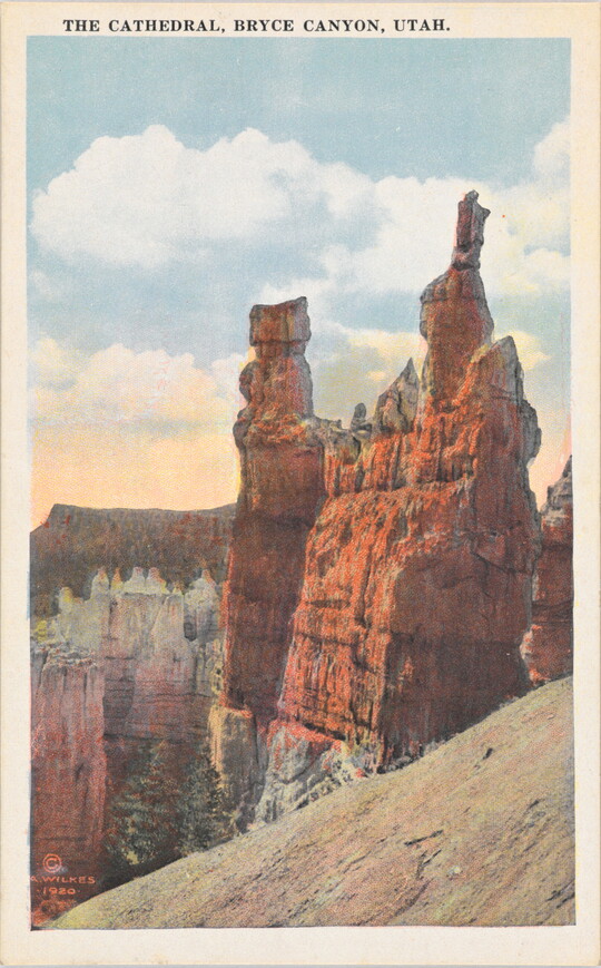A color postcard of vertical rock formations in a desert landscape.