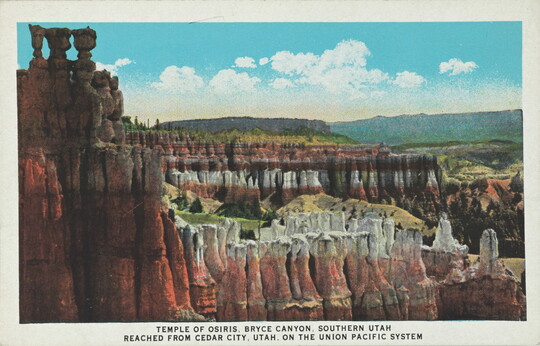 A color postcard of multicolored rocky cliffs and tall rock formations.