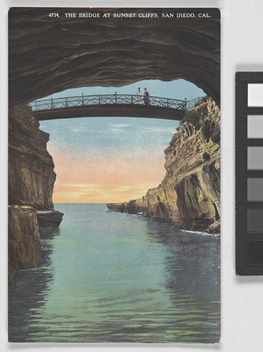 A color postcard of a bridge spanning between cliffs over water as the sun sets in the background.