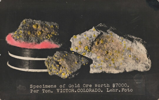 A color postcard of multiple nuggets of gold on a black background.
