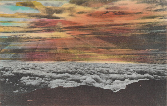 A color photograph postcard of dark mountains above a layer of white clouds and colorful streaks of light coming from clouds in the sky.
