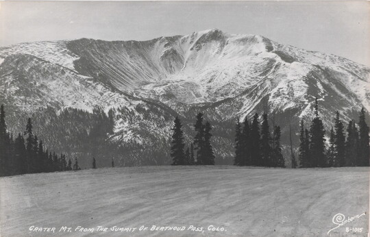 A black-and-white postcard of a crater in a large, snowy mountain.