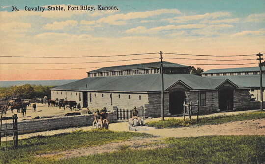A color postcard of a stone stable with horses in a paddock and riders around the perimeter.
