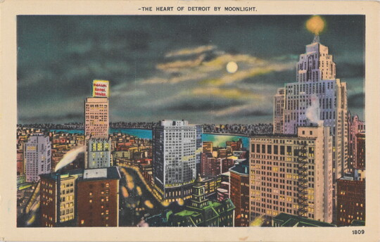 A color photograph postcard of a riverside city at night, buildings lit up, and the moon shining through dark clouds.