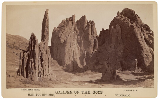 A sepia-toned photograph of large rock formations in a barren landscape.