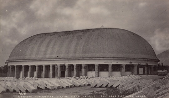 A black-and-white photograph of a large, oval-shaped building with a dome.