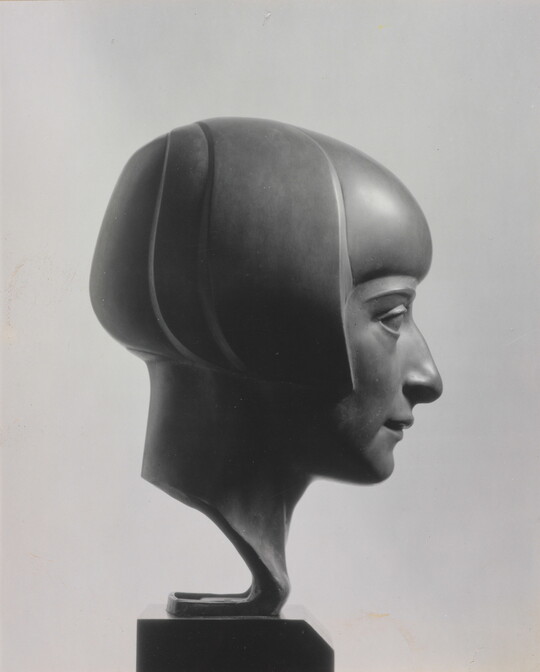 A black-and-white photograph of a bronze bust of a woman in profile with a bobbed haircut.