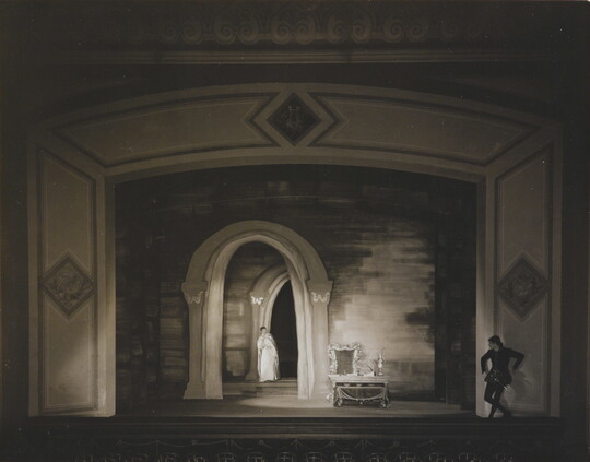 A black-and-white photograph of a woman and man performing on a stage.
