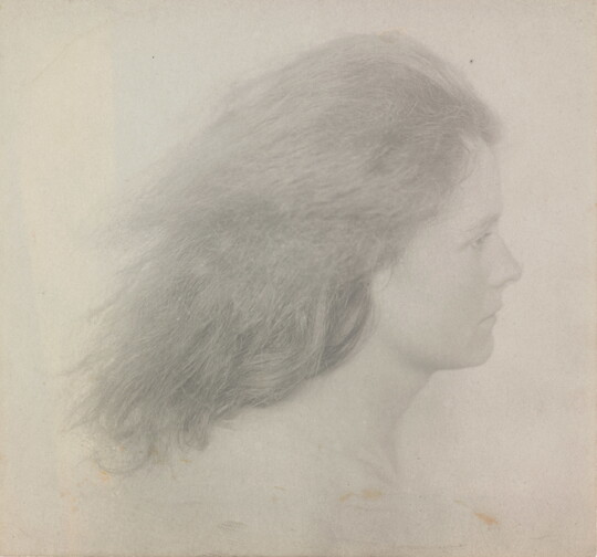 A black-and-white photograph of a young White woman in profile from the neck up with her shoulder-length hair streaming behind her.