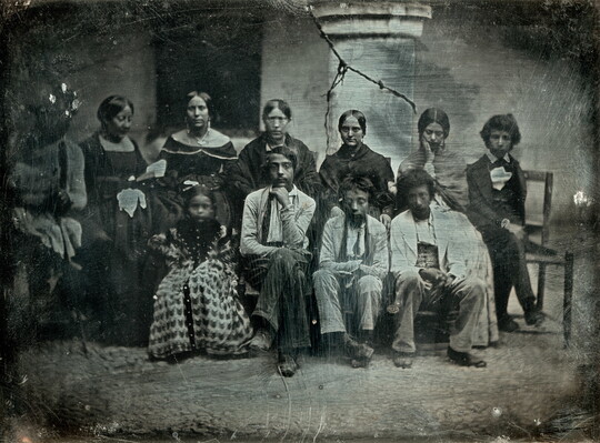 A black-and-white formal group portrait photograph of a medium-skinned group of adults and children.