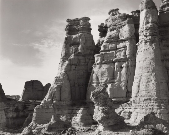 A black-and-white photograph of large rock formations.