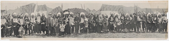 A black-and-white panoramic photograph of a large group of people, some in western-style clothing and others in Native American dress.