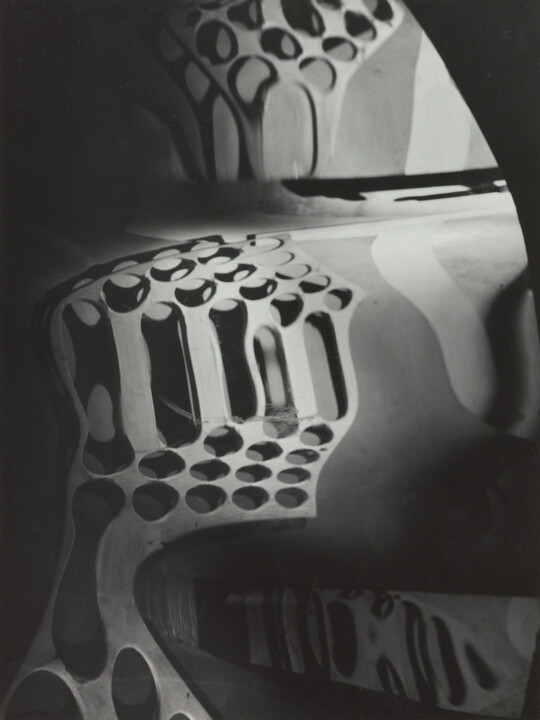 A black-and-white photograph of circular shapes distorted by a wavy mirror.