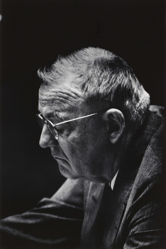 A black-and-white photograph of an older White man wearing glasses, pictured in profile.